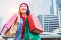 Portrait of an excited beautiful young girl wear shirt and wool hat holding many shopping bags and smile. With copy space. Royalty Free Stock Photo