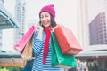 Portrait of an excited beautiful young girl wear shirt and wool hat holding many shopping bags and smile. With copy space. Royalty Free Stock Photo