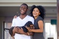 Portrait of excited black family posing with dog near home