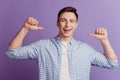 Portrait of excited boasting guy open mouth indicate thumb himself on purple background