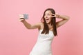 Portrait of excited bride woman in lace white wedding dress showing victory sign, doing taking selfie shot on mobile Royalty Free Stock Photo