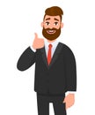 Portrait of excited business man dressed in black formal wear showing thumbs up sign. Deal, like, agree, approve, accept.