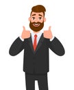 Portrait of excited business man dressed in black formal wear showing thumbs up sign. Deal, like, agree, approve, accept. Royalty Free Stock Photo