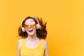 Portrait of excited cheerful laughter funny comic woman in orange glasses in headphones with fluttering hair isolated on