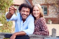Portrait Of Excited Couple By Gate Holding House Keys Outside New Home In Countryside On Moving Day Royalty Free Stock Photo