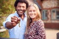 Portrait Of Excited Couple By Gate Holding House Keys Outside New Home In Countryside On Moving Day Royalty Free Stock Photo