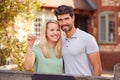 Portrait Of Excited Couple By Gate Holding House Keys Outside New Home In Countryside On Moving Day Royalty Free Stock Photo