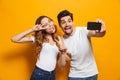 Portrait of excited couple man and woman taking selfie photo on Royalty Free Stock Photo