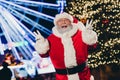 Portrait of excited funky santa grandfather two hands fingers demonstrate v-sign enjoy newyear time lights outdoors Royalty Free Stock Photo