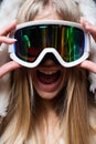Portrait of excited funny woman snowboarder or skier in snow goggles.