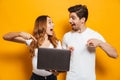 Portrait of excited happy man and woman holding and pointing fin Royalty Free Stock Photo