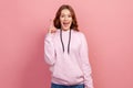 Portrait of excited inspired teen with brown hair pointing finger up looking at camera with toothy smile, happy with new great