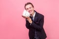 Portrait of excited man in elegant suit hugging adorable white rabbit bunny. isolated on pink background Royalty Free Stock Photo