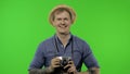 Portrait of excited man tourist photographer with retro photo camera. Chroma key