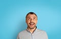 Portrait Of Excited Mature Man Looking Up Over Blue Background Royalty Free Stock Photo