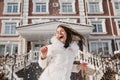 Portrait excited playful girl having fun with snow in frozen sunny morning on street. True emotions, laughing with