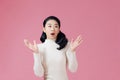 Portrait of excited screaming young asian woman standing isolated over pink background, Wow and surprised concept Royalty Free Stock Photo