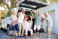Portrait Of Excited Senior Friends Loading Luggage Into Trunk Of Car About To Leave For Vacation
