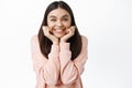 Portrait of excited smiling girl leaning on face and looking enthusiastic at camera, gazing at something with interest Royalty Free Stock Photo