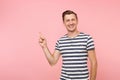 Portrait excited smiling young man wearing striped t-shirt pointing index finger aside on copy space isolated on Royalty Free Stock Photo