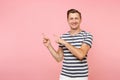 Portrait excited smiling young man wearing striped t-shirt pointing index fingers aside on copy space isolated on Royalty Free Stock Photo