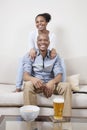 Portrait of excited young African American couple watching TV Royalty Free Stock Photo