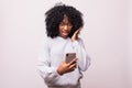 Portrait of excited young african woman look at screen mobile phone isolated over white background Royalty Free Stock Photo