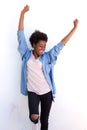 Excited young african woman standing with her arms raised against white wall Royalty Free Stock Photo