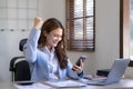 Portrait of an excited young asian girl using laptop computer and celebrating success for online. Royalty Free Stock Photo