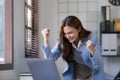 Portrait of an excited young asian girl using laptop computer and celebrating success for online. Royalty Free Stock Photo