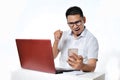 Portrait of excited Young Asian man sitting near laptop on the desk successfully completed the work as online freelancer Royalty Free Stock Photo