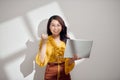 Portrait of an excited young blonde girl holding laptop computer and celebrating success isolated over white background Royalty Free Stock Photo