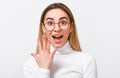 Portrait of excited young blonde woman wearing white blouse and round trendy transparent glasses, showing engagement ring on her Royalty Free Stock Photo