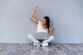Portrait of excited young casual girl celebrating success while sitting with laptop computer isolated over gray Royalty Free Stock Photo