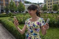 Excited young girl showing bunch of money banknotes and holding mobile phone Royalty Free Stock Photo