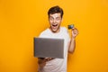 Portrait of an excited young man holding laptop computer Royalty Free Stock Photo