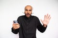 Portrait of excited young man with mobile phone waving hand Royalty Free Stock Photo