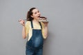 Portrait of an excited young pregnant woman eating chocolate cake Royalty Free Stock Photo