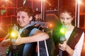 Excited teen boy and girl aiming laser gun at other players Royalty Free Stock Photo