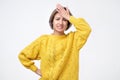 Portrait of excited young woman in yellow sweater holding her head Royalty Free Stock Photo