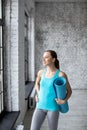 Portrait of exercise fitness woman ready for workout, standing and holding blue yoga mat in sport club studio Royalty Free Stock Photo
