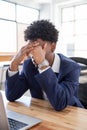 Portrait of exhausted male office worker covering eyes