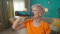 Portrait of an exhausted but satisfied grayhaired elderly woman after a workout in the living room. Tired elderly woman