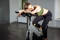 Portrait of exhausted woman spinning pedals on exercise bike Royalty Free Stock Photo