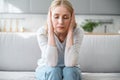 Portrait of exhausted woman suffering from disturbing noisy sound at home