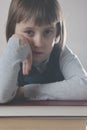 Portrait of exhauusted young beautiful child girl with books. Vertical image