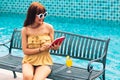 Portrait of an Exited young asians girl looking her mobile phone,smart phone ot tablet sit on chair