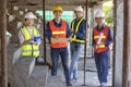 Portrait of experienced diversity team of engineer, architect, worker and safety manager smiling together at the construction site Royalty Free Stock Photo