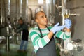 Latin american winemaker inspecting quality of wine at winery