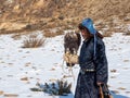 Portrait of an experienced male hunter with a hunting golden eagle. Eagle hunters are people who train and hunt with golden eagles